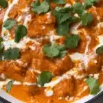 Delicious butter chicken served with rice and garnished with fresh cilantro