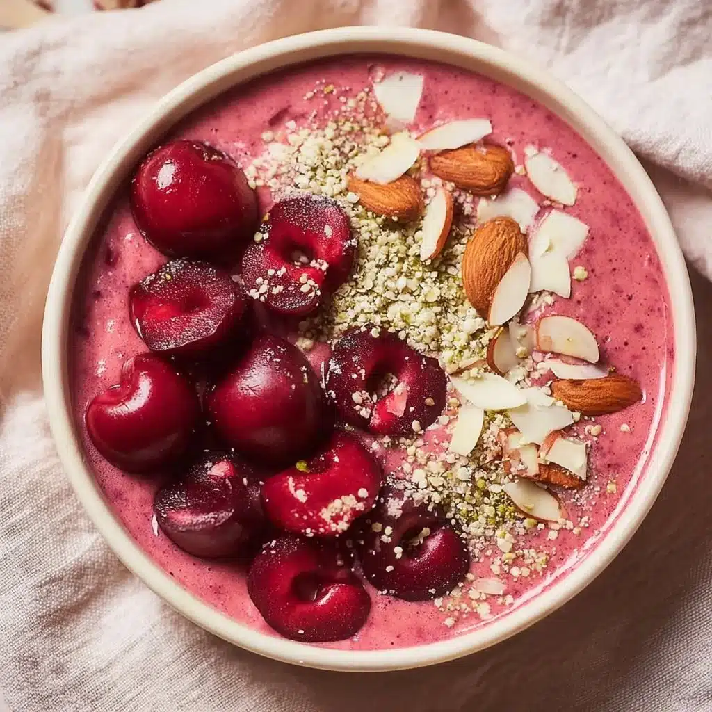 Delicious cherry smoothie bowl topped with fresh fruits and granola