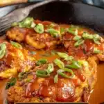 Delicious Chicken Diablo served on a platter with fresh herbs and spices.