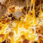 Delicious chicken enchilada casserole topped with cheese and fresh ingredients