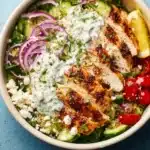 Delicious Greek Chicken Bowls with marinated chicken, fresh veggies, and tzatziki sauce
