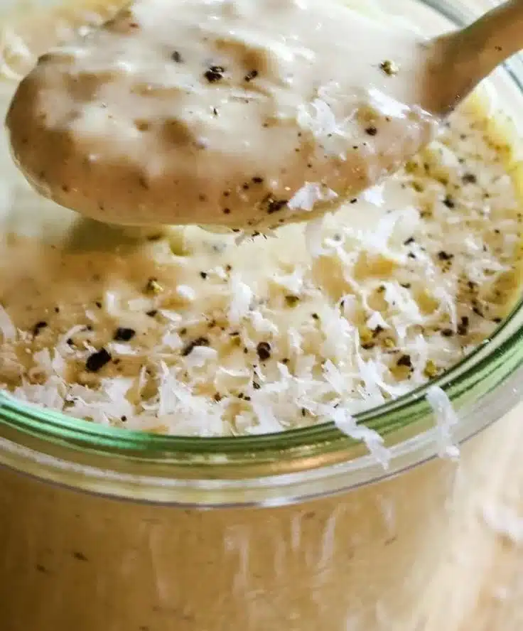Homemade healthy Caesar salad dressing in a glass jar with fresh ingredients