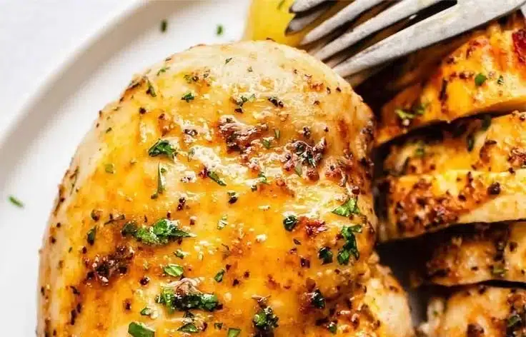 Baked chicken breasts seasoned and ready to serve on a plate.