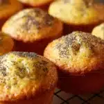 Freshly baked lemon poppyseed muffins on a wooden table.