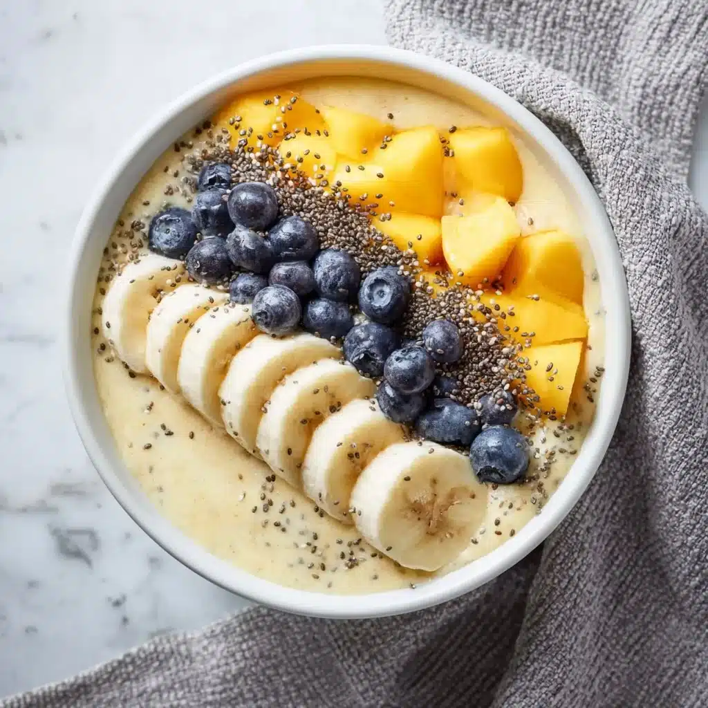 Luxurious mango smoothie bowl topped with fresh fruits and nuts