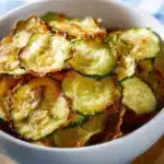 Crispy salt and vinegar zucchini chips on a plate fresh from the oven