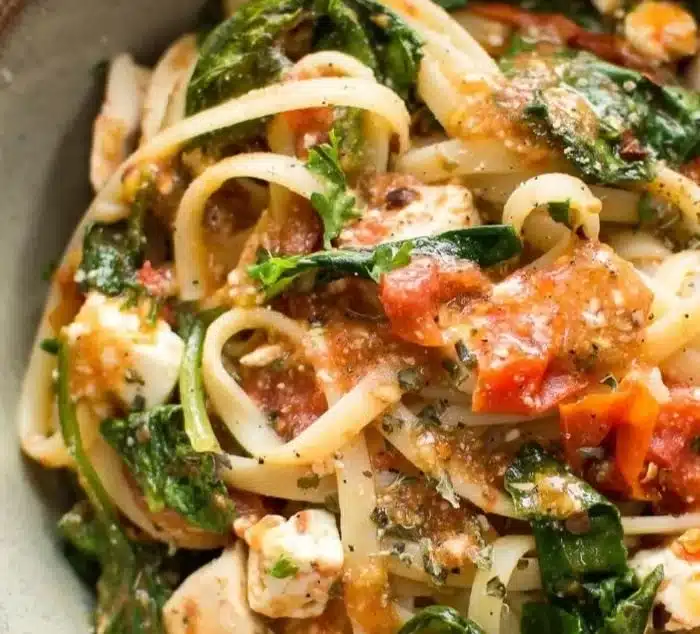 Bowl of Chicken Feta Spinach Pasta garnished with herbs