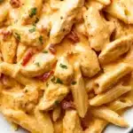Creamy Cajun Chicken Pasta served in a white bowl with herbs and spices