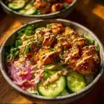 Crispy chicken drizzled with creamy spicy sauce on a plate