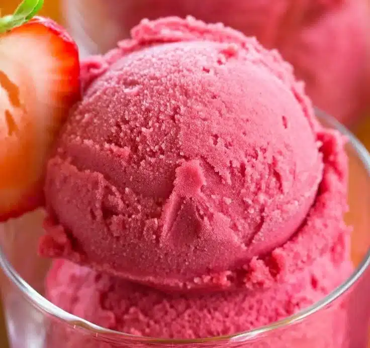 Bowl of easy 3 ingredient strawberry sorbet garnished with fresh strawberries