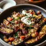 Mediterranean roasted eggplant garnished with herbs and spices.