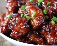 Delicious sticky honey chicken drizzled with honey glaze on a plate.