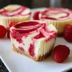 Delicious mini raspberry swirl cheesecakes displayed on a dessert table