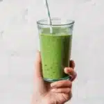 A refreshing spinach smoothie in a glass with vibrant green color and healthy ingredients.