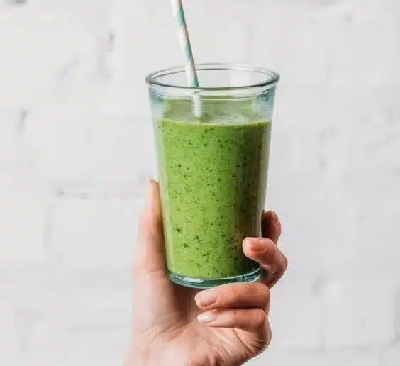 A refreshing spinach smoothie in a glass with vibrant green color and healthy ingredients.