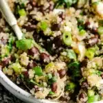 Colorful black bean quinoa salad with vegetables and dressing in a bowl