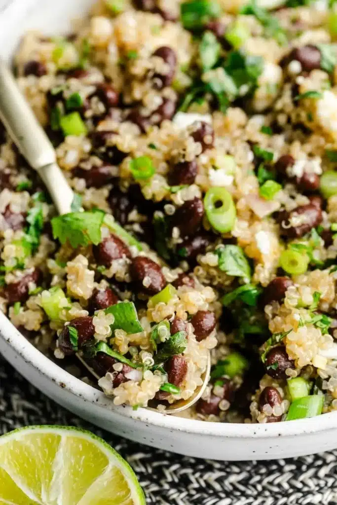 Colorful black bean quinoa salad with vegetables and dressing in a bowl