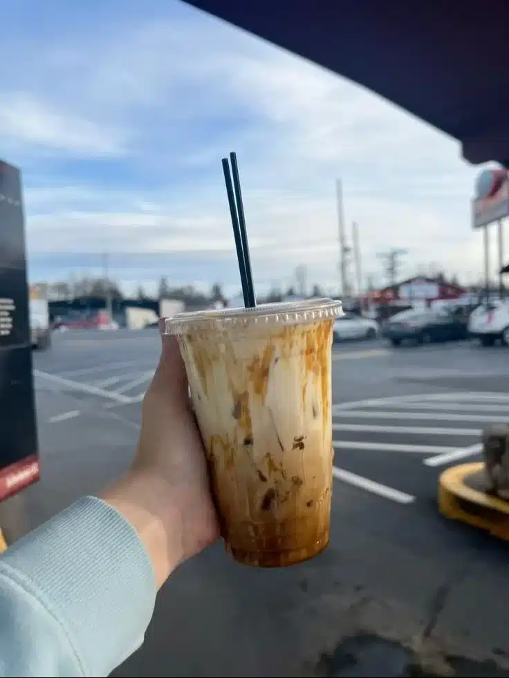 Caramel and Vanilla Iced Latte in a glass with whipped cream and caramel drizzle