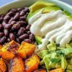 Colorful Sweet Potato Quinoa Bowl topped with fresh vegetables and herbs.