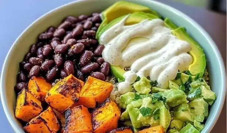 Colorful Sweet Potato Quinoa Bowl topped with fresh vegetables and herbs.